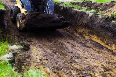 onun kova zemin ile vakıf çukurunda mini yükleyici kırpılmış görünümü