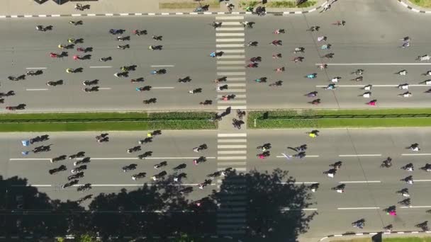 Antenn uppifrån och ner på stads vägen med massor av cyklister som rider på sina cyklar — Stockvideo