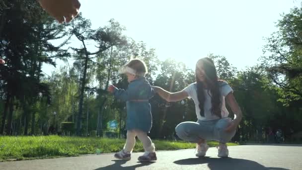 Kärleksfulla föräldrar med småbarn dotter tillbringar fritiden i sommarträdgård — Stockvideo