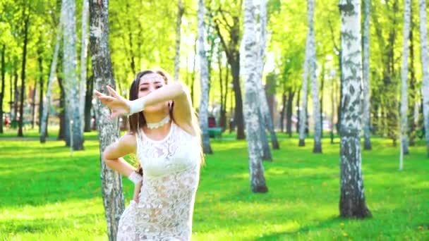 Sonnenstrahlen auf schöne Frau in sexy Kostüm tanzen im grünen Park — Stockvideo