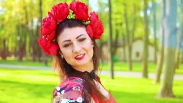 Porträt einer attraktiven Tänzerin in volkstümlicher Tracht im sonnenbeschienenen grünen Park — Stockvideo
