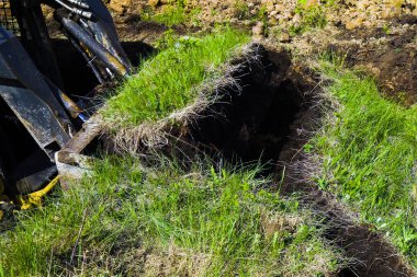 toprak işleri sırasında buldozer kovası ile kazılmış çimenli yüzey