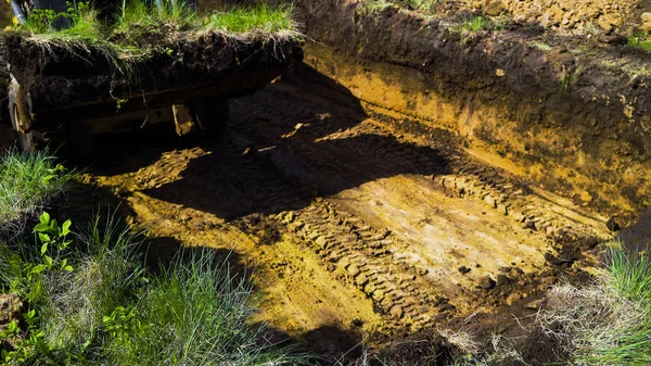 ön planda yeşil çim ile çamurlu siper ekskavatör tekerlekleri izleri