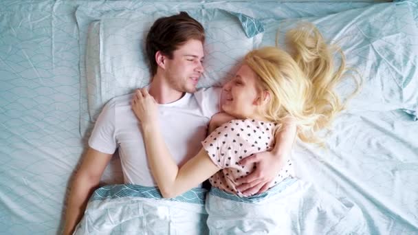 Κορυφαία θέα ζουμ στο ευτυχισμένο ζευγάρι ξαπλωμένο στο κρεβάτι πρόσωπο με πρόσωπο το πρωί — Αρχείο Βίντεο