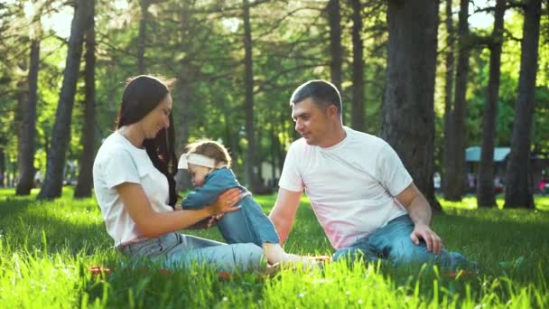 Счастливая традиционная семья с маленькой девочкой проводят время вместе в солнечном парке — стоковое видео