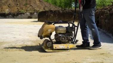temel çukurunda yüzey plakavibratörü ile kum ait adamın kısmi görünümü
