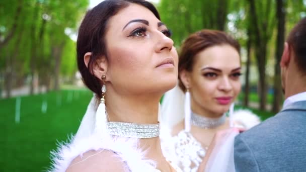 Closeup faces of young people in wedding clothes stand still posing for camera — Stock Video