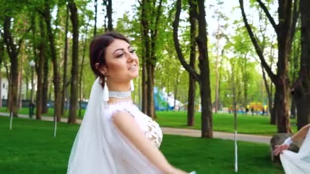 Красивые женщины в костюмах невесты танцуют в солнечном парке — стоковое видео