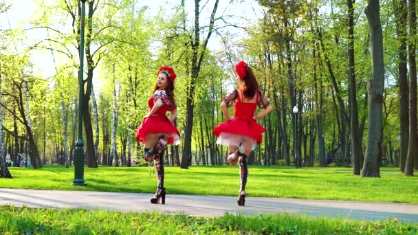 Pretty kvinnliga dansare i folklore stil kostymer och blomma pannsmycken i Park — Stockvideo