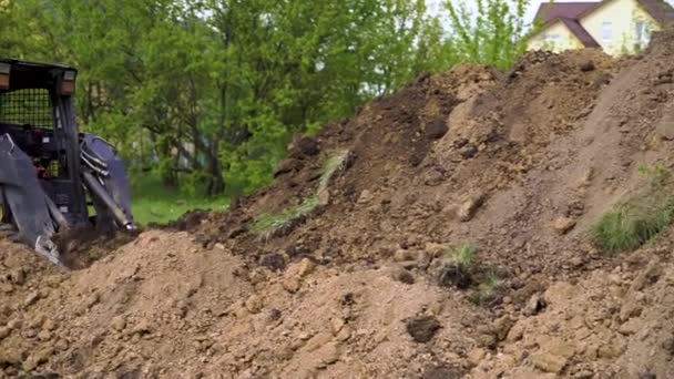 掘削機は、地球の作業中にバケツから土壌をアンロード — ストック動画