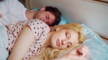 sabah yatakta genç çift sarılıyor ve kadın gözlerini açar