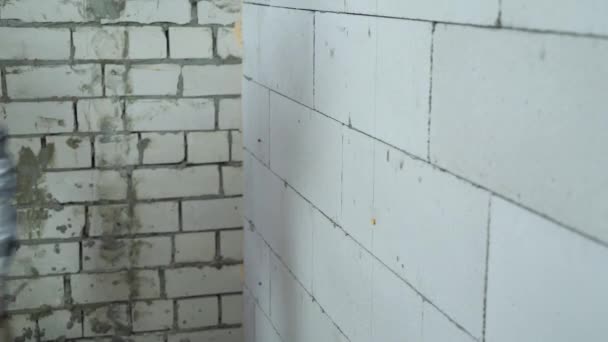 Trabalhador da construção parafuso em parafusos na parede do bloco com broca elétrica — Vídeo de Stock
