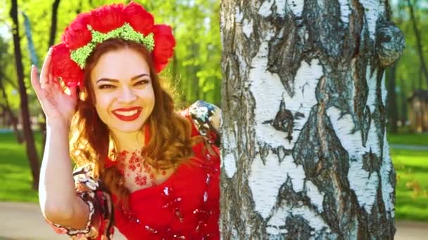 자작 나무에서 들여다 보는 민속 스타일의 의상을 입은 예쁜 여성의 초상화 — 비디오