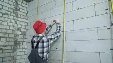 inşaat giyim ve kırmızı kapak blok duvara inşaat kelepçeleri ekler