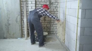iş giyim ve kırmızı kapak sıva havalandırılmış beton blok duvar adam