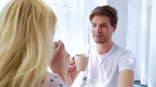 Über der Schulter Aufnahme von schönen Paar trinkt Morgenkaffee in hellen Raum — Stockvideo