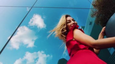 Kentsel ortamda dans kırmızı elbiseli seksi kadın düşük açı çekim