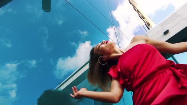 Снимок чувственной женщины в красном платье, танцующей на зеркальной поверхности — стоковое видео