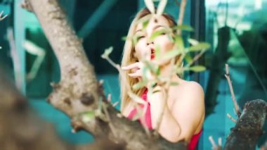 yavaş hareket şehir merkezinde ağaçların arkasında seksi sarışın kadın dansları