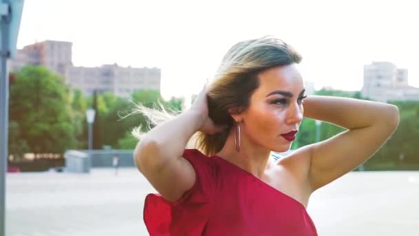 Hermosa mujer rubia con maquillaje brillante tocando su cabello en el viento — Vídeo de stock