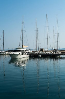 yelkenli yatlar güneşli bir günde koyda dinlenerek suya yansıdı