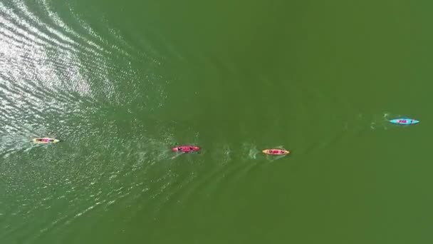 Aereo top down di kayak colorati con pagaiatori sulla superficie del fiume che riflette il sole — Video Stock