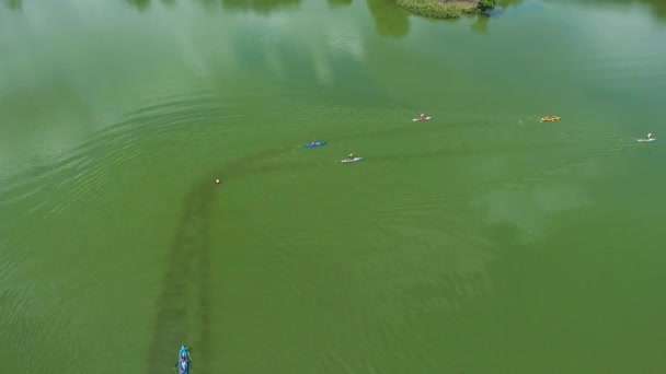 Aerial of water race with kayakers and stand up paddle boarders on green river — Stock Video