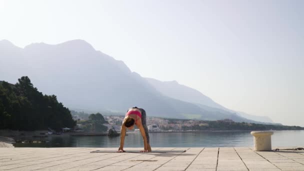 Treinamento de ioga por mulher sporty fit à beira-mar na luz do sol da manhã — Vídeo de Stock