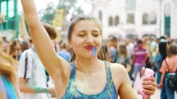 Kharkiv, Ucrania - 26 de mayo de 2019: mujer feliz sopla pintura Holi de su palma de la mano — Vídeo de stock