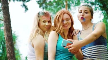 Holi boyalar üç genç kadın düşük açı mobil selfie fotoğraf çekmek