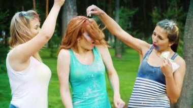neşeli genç kadınlar yaz parkında Holi festivalinde renkli toz serpin