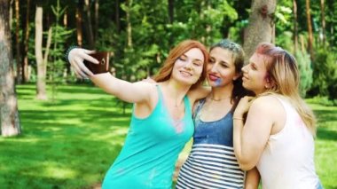 üç kadın arkadaş yavaş çekimde Holi fest sonra akıllı telefonda selfie yapmak