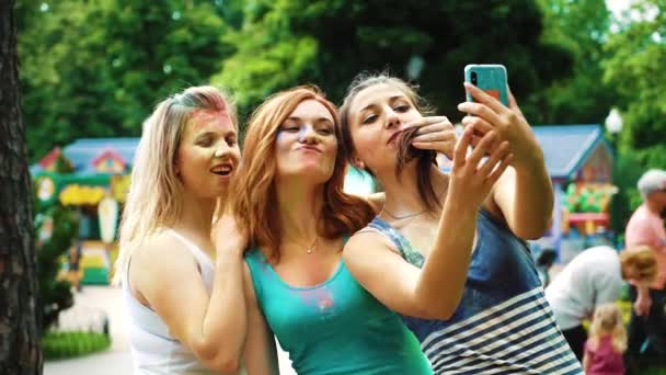 Haciendo caras graciosas para selfie foto de chicas en pinturas Holi — Vídeos de Stock
