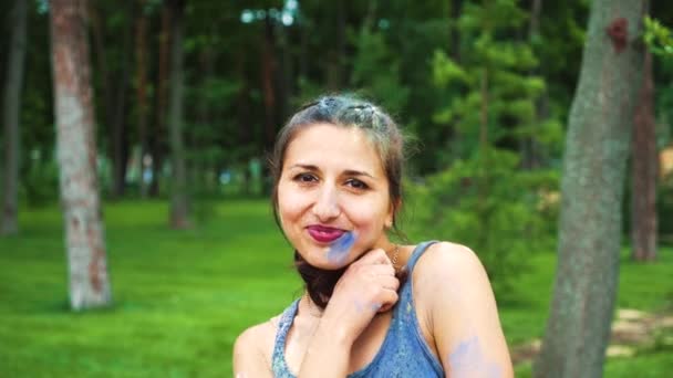 Retrato de mujer joven en polvo festival Holi sonriendo a la cámara — Vídeos de Stock