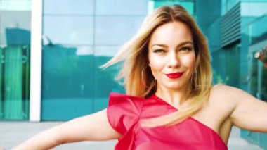 mutlu sarışın kadın sokakta dans eder ve hareketli kamera izler