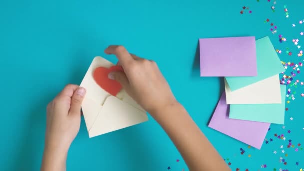 Arriba hacia abajo tiro de adolescente manos preparación de día de San Valentín tarjeta — Vídeo de stock