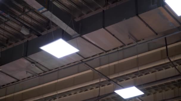 lange Rohre des industriellen HVAC-Systems und Lampen an der Decke eines großen Einkaufszentrums