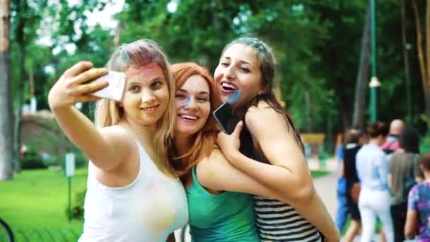 Kharkiv, Ukraine - May 26, 2019: young women in Holi paints take selfie on phone — Stock Video