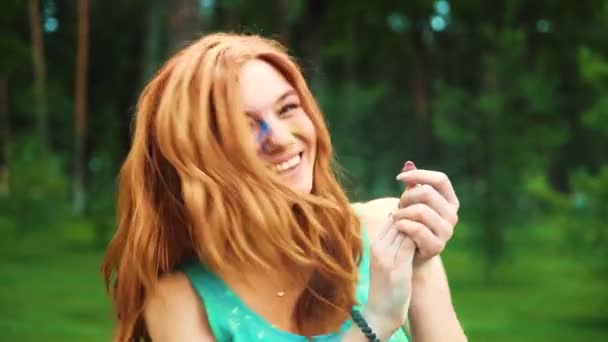 ホーリーパウダーで覆われたカメラで笑う赤毛の若い女性の肖像画 — ストック動画