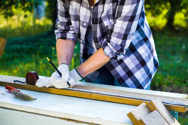 handywoman kırpılmış çekim ahşap tahta önlemler ve kalem ile işareti koyar