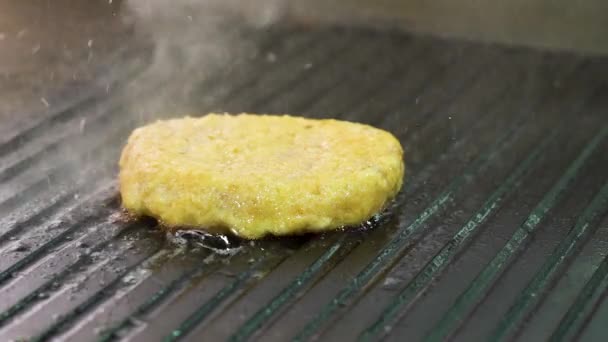Burbujas de primer plano y espolvorear aceite mientras asar hamburguesa de pollo en la estufa — Vídeo de stock