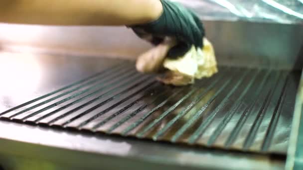 Nahaufnahme Koch Hand in Hand wischt zusätzliches Öl vom großen dampfenden Grill — Stockvideo