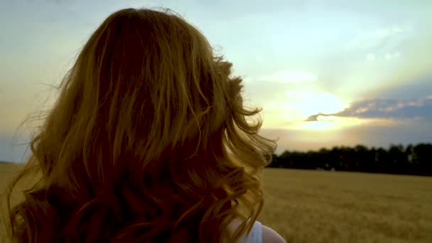 Vista posteriore della donna guardando la luce del sole che irrompe attraverso le nuvole al tramonto — Video Stock