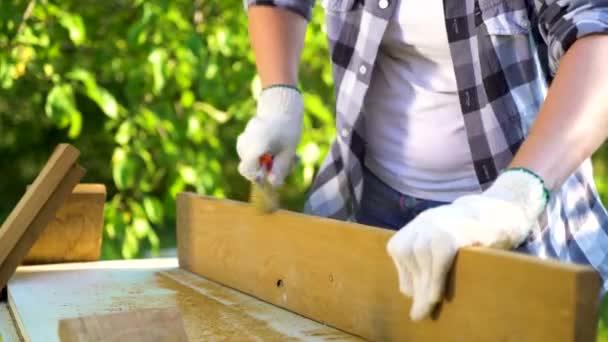 裁剪拍摄的手工艺妇女抓木板用金属刷在花园里 — 图库视频影像