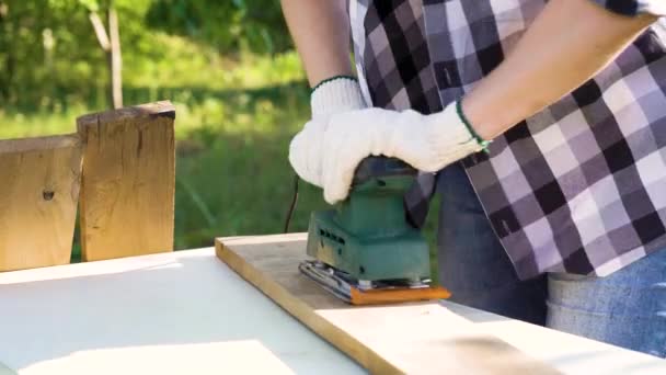 Primo piano delle mani della donna in guanti protettivi carteggiatura vecchia tavola di legno — Video Stock