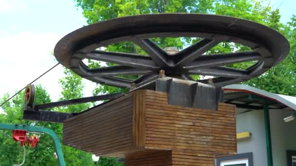 Großes Metallrad der Seilbahn dreht sich im Sommer horizontal im Stadtpark — Stockvideo