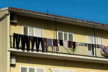 köy evinin balkonunda çamaşır hattına asılı koyu giysi ve iç çamaşırı