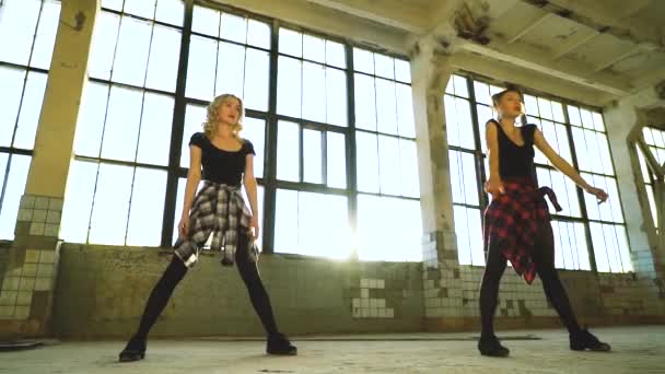 Tiro de arco de ángulo bajo de bailarinas entrenando en estudio loft con destello de lente — Vídeos de Stock