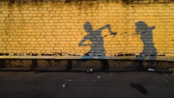 Sagome di due donne che danzano sul tetto industriale contro il muro di mattoni al tramonto — Video Stock