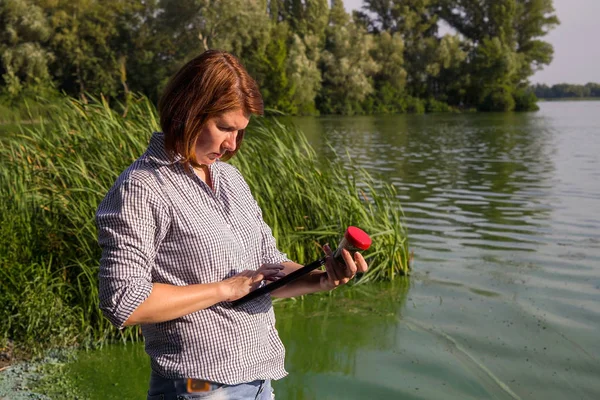 tablet üzerinde nehirde alınan yeşil yosun veri girerek ekolojist yan görünümü